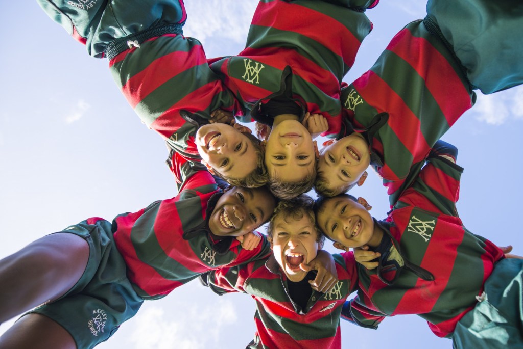 Boys from akeley wood school, looking down at the camera in a circle wearing their rugby shirts.